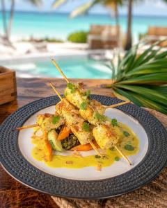 a plate of food with shrimp and vegetables on a table at Kano Boutique Hotel Paje in Paje