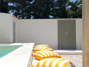 a row of yellow and white pillows sitting next to a pool at LE SORELLE Sea front -villa whit private pool in Scopello +57 photos
