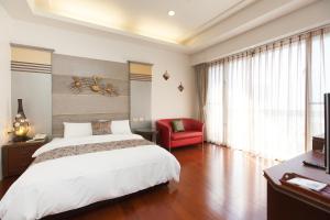 - une chambre avec un lit blanc et une chaise rouge dans l'établissement Chun Feng Cao Tang Homestay, à Yuanshan