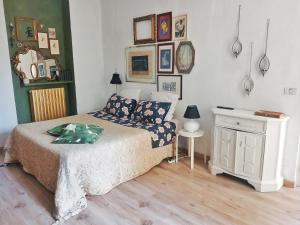 a bedroom with a bed and a table and pictures on the wall at RaMaya casa d'artista 2 in Biella