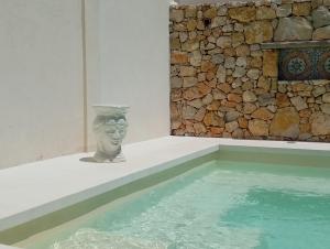 a vase sitting next to a pool of water at LE SORELLE Sea front -villa whit private pool in Scopello
