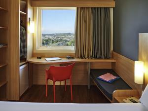a room with a desk and a chair and a window at ibis Sorocaba in Sorocaba +112 photos