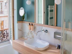 a bathroom with a sink and a mirror at Mercure Lyon Centre Beaux-Arts in Lyon +59 photos
