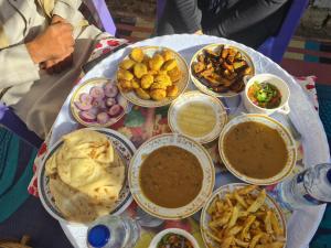 a table topped with lots of different types of food at White Desert Experience in Bawati