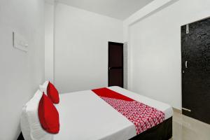 a white room with a bed with red pillows at Hotel O Radha Krishna Family Hotel in Naubatpur +21 photos