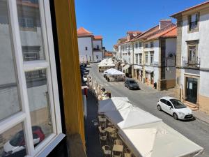 a view from a window of a street with parked cars at Casa das Andorinhas - AL in Castelo de Vide