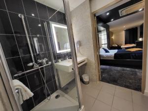 a bathroom with a shower and a sink and a bedroom at Accueil Hôtel Paris Pigalle Montmartre - Hôtel rénové in Paris +95 photos