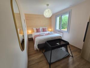 a small bedroom with a bed and a mirror at Les Reflets Verts - Lac de Vouglans in Maisod
