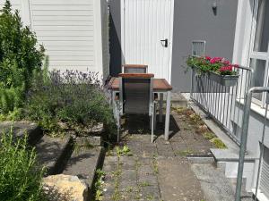 a table and a chair sitting outside of a house at Conny's Ferienwohnung in Bietigheim-Bissingen