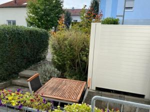 a wooden table and bench in a garden with flowers at Conny's Ferienwohnung in Bietigheim-Bissingen