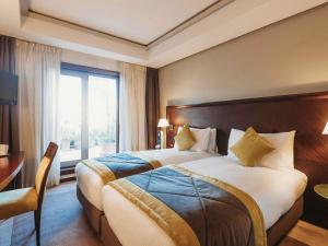 a hotel room with a large bed and a window at Le Diwan Hotel Rabat - MGallery Collection in Rabat +147 photos