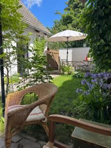 a wicker chair and an umbrella in a garden at Südfrankreich bei Berlin in Werder