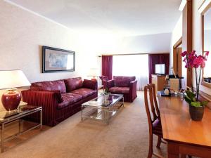 a living room with a couch and a table at Mercure Luxembourg Kikuoka Golf & Spa in Canach