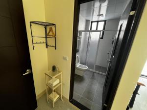 a bathroom with a toilet and a glass shower stall at Green Home in Yuli