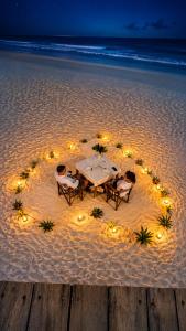 a table with chairs and lights on the beach at Zava Nungwi in Nungwi