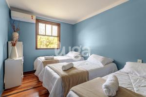 three beds in a room with blue walls at Vieira Eco Inn – Flex Suite Vanir in Orleans