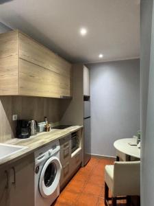 a kitchen with a washing machine and a table at Green Suite Skiathos in Skiathos