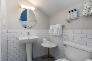 a white bathroom with a sink and a mirror at Prentiss House by Thatch in Cambridge +156 photos