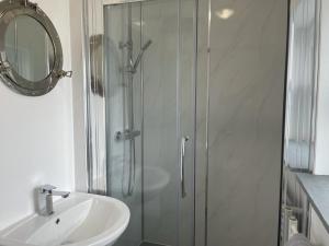 a bathroom with a shower and a sink and a mirror at Sea Scape in Whitstable