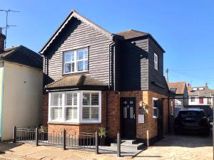 a brick house with a black roof at Sea Scape in Whitstable