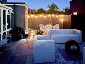 a white couch and chairs on a patio with lights at Sea Scape in Whitstable +13 photos