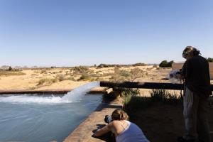 a man and a woman taking a picture of water at White Desert Experience in Bawati