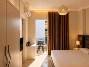 a bedroom with a bed and a desk and a window at Hotel Mare in Ksamil +35 photos