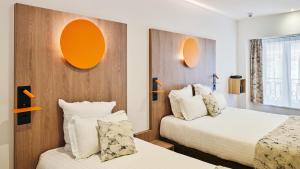 a hotel room with two beds and orange mirrors at Hôtel Carré Vieux Port in Marseille +32 photos