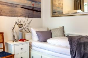 a room with a bed and a picture on the wall at Commandeur-Huus Wohnung 1 in Borkum