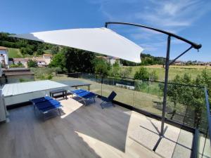 a patio with a white umbrella and blue chairs at Appartamento Cataleya in Cuccurano