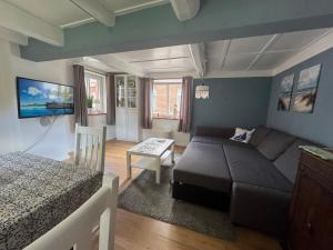 a living room with a couch and a bed at Dat Lütte Huus - Ferienhaus nahe Greetsiel in Krummhörn