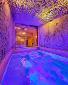 a hot tub in a room with purple lighting at Bayar Cave Suites Special Class in Ürgüp