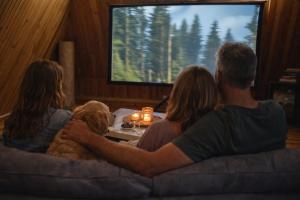 a group of people sitting on a couch with a dog at DOM LAS - natura, relaks, jacuzzi. in Mianów