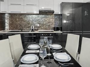 a kitchen with a table with plates and wine glasses at Konstanzer Stefan 15 - Old Town Apt - Palas Mall - AC in Iaşi