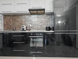 a kitchen with black appliances and white cabinets at Konstanzer Stefan 15 - Old Town Apt - Palas Mall - AC in Iaşi +11 photos