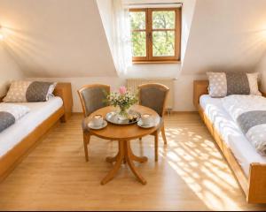 a room with two beds and a table and chairs at Pension Rose-Monteurzimmer & Ferienzimmer - Bodensee-Selbstversorger mit Küchen, Parken & Kaffee & Wlan frei in Ravensburg