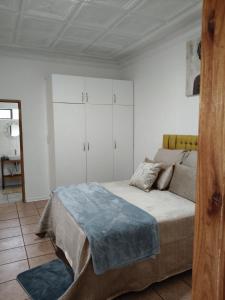 a bedroom with a bed and white cabinets at The Museum in Sabie