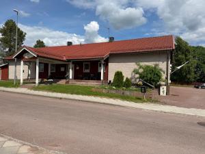a house with a red roof on the side of a street at Målkullorna Hostel in Mora