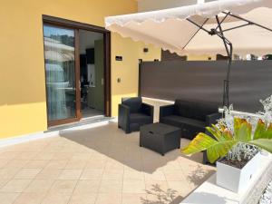 a patio with a couch and an umbrella at Blue Cave b&b in Palinuro +26 photos