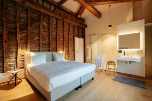 a bedroom with a bed and a wooden wall at Château du Pont d'Oye in Habay-la-Neuve +67 photos