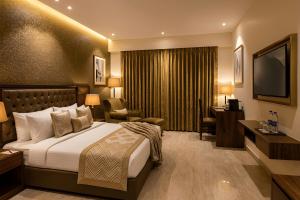 a hotel room with a bed and a television at Hotel The Mirage in Gil