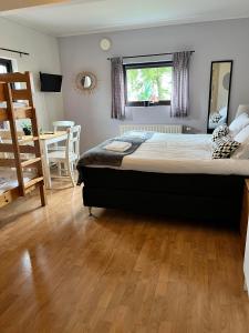 a bedroom with a large bed with a wooden floor at Rödlix Vandrarhem & Camping in Tvååker