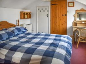 a bedroom with a blue and white bed and a door at Rivers View - Uk49662 in Braunton