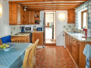 a kitchen with wooden cabinets and a table with a plate on it at Rivers View - Uk49662 in Braunton