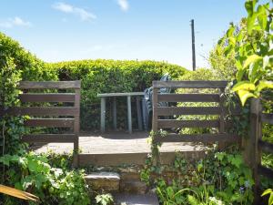 a wooden fence with a table in a garden at Rivers View - Uk49662 in Braunton