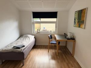 ein Schlafzimmer mit Schreibtisch, Bett und Tisch in der Unterkunft Room for rent Landsbyen in Videbæk