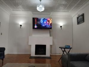 a living room with a fireplace and a flat screen tv at The Museum in Sabie