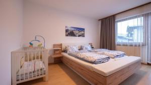 a bedroom with a crib and a bed in a room at Ferienhaus Krismer in Fügen