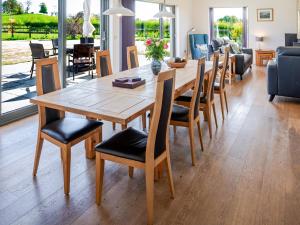 a wooden table and chairs in a living room at The Longhouse At Threave in Castle Douglas