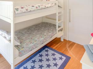 a bunk bed in a childs bedroom with a blue rug at The Longhouse At Threave in Castle Douglas